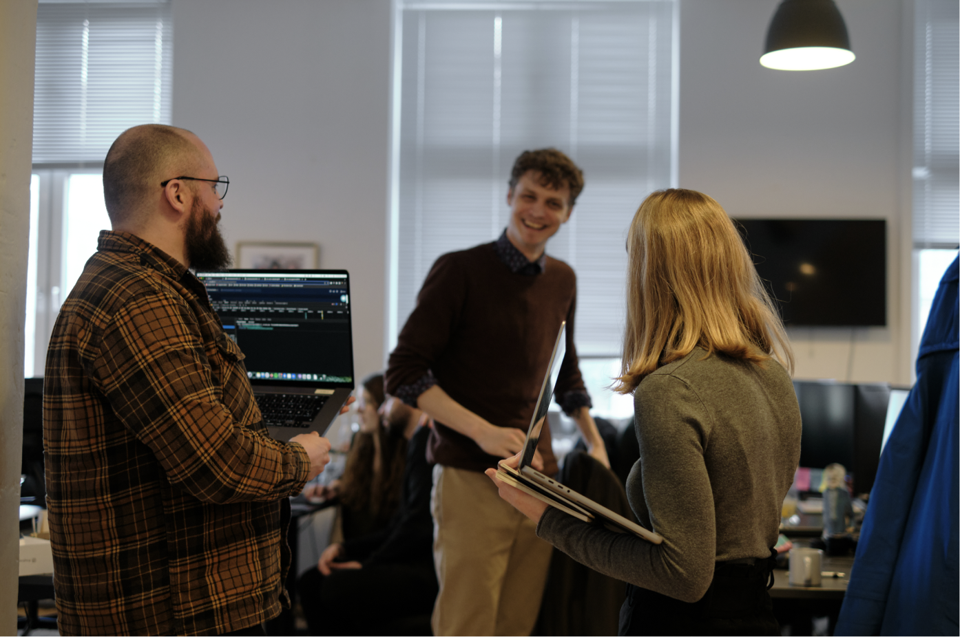 Photo of three Clerk.io employees chatting in the office.