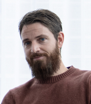 Photo of a man smiling looking at the camera.